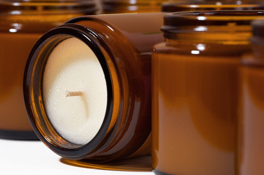 Soy candle in amber jar with soybeans and greenery