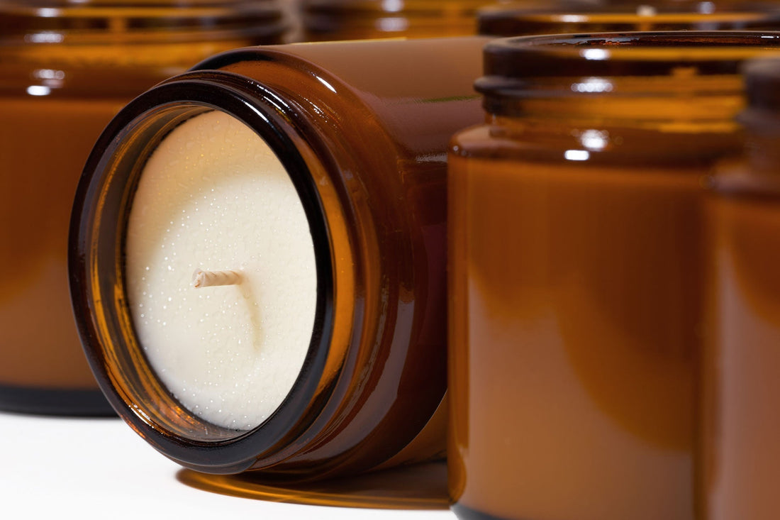 Soy candle in amber jar with soybeans and greenery
